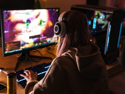 fille avec casque sur la tête devant un écran d'ordinateur