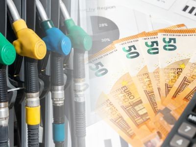 4 pistolets de pompe à essence accrochés à la pompe et pluisuers billet de 50 euros et une calculatrice