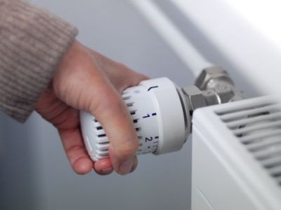 main tournant un thermostat de radiateur