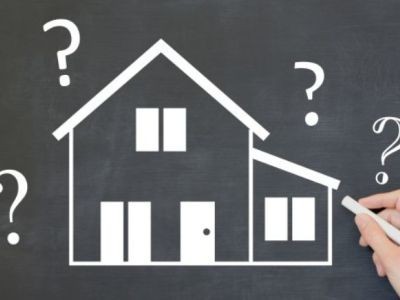 maison dessinée à la craie avec des points d'interrogation main avec une craie