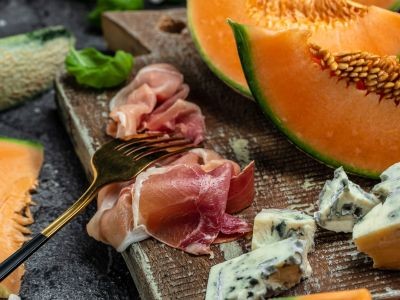 tranches de jambon de melon de fromage sur une planche avec une fourchette