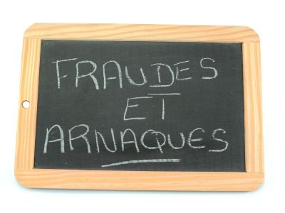 ardoise avec les mots arnaques et fraudes écris à la craie