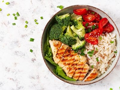 assiette contenant une escalope de poulet des brocolis du riz et des tomates