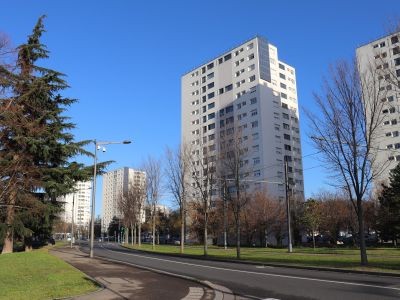 tous d'immeubles route qui passe devant avec de chaque côté des arbres, jardin et lampadaires