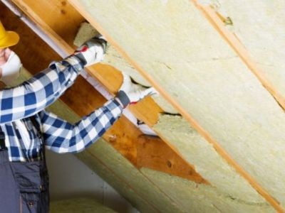 homme posant laine de verre sur toiture